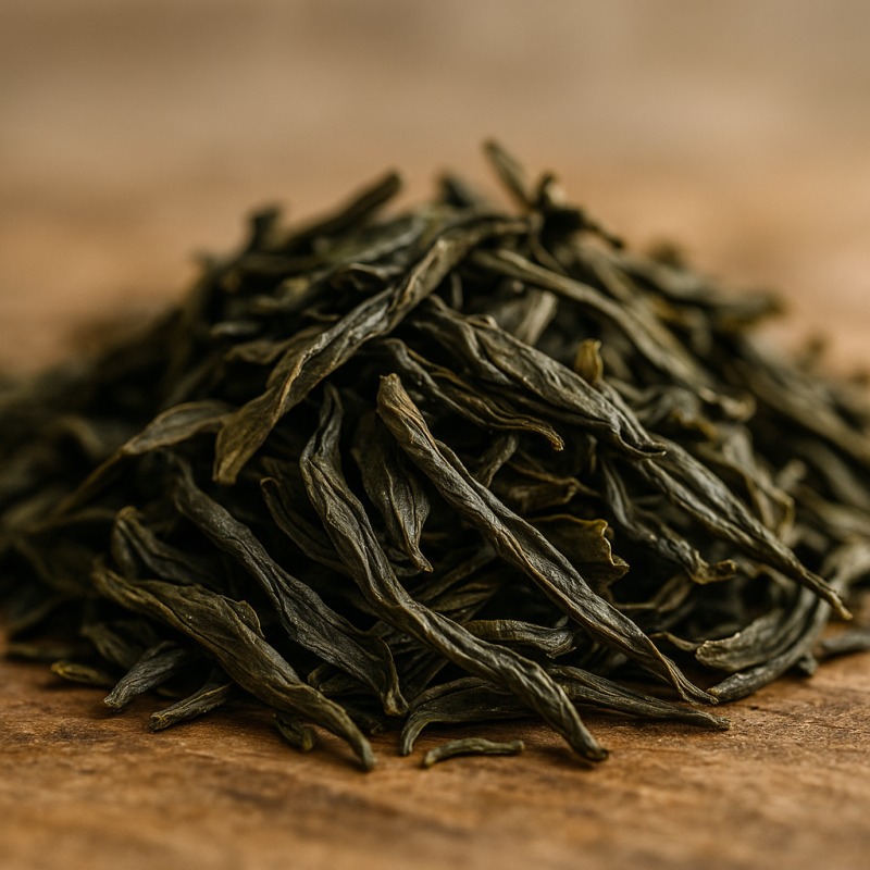 Macro shot of whole loose leaf tea leaves resting on a wooden surface with soft natural lighting.